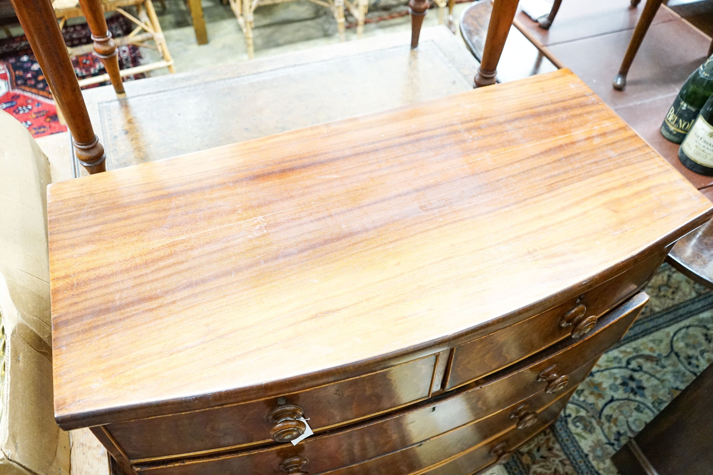 A Victorian mahogany bow fronted chest of drawers (lacking feet), width 105cm, depth 50cm, height 92cm